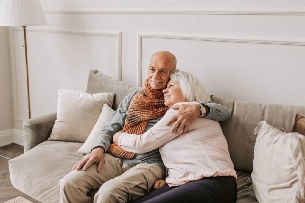 Happy retired couple sat on a sofa